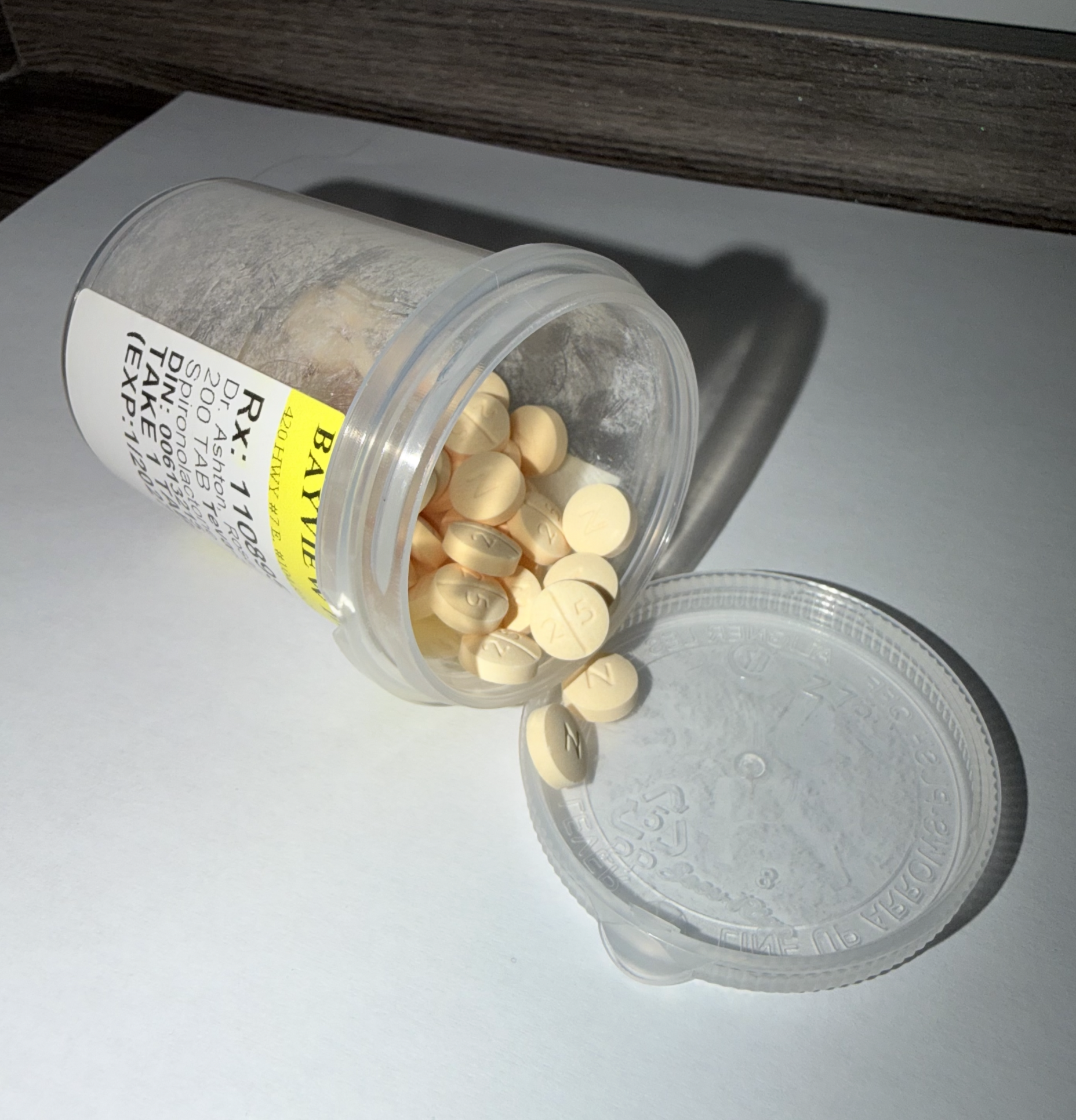 Opened pill container with circular pills pouring out.